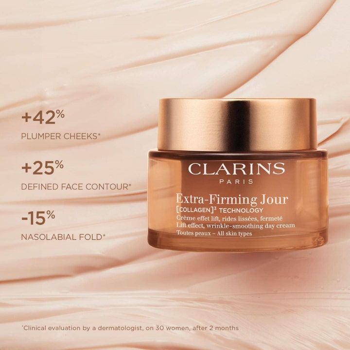 Clarins Extra-Firming Jour 50 ml silottava päivävoide kultaisessa lasipurkissa vaalean voiteen päällä.