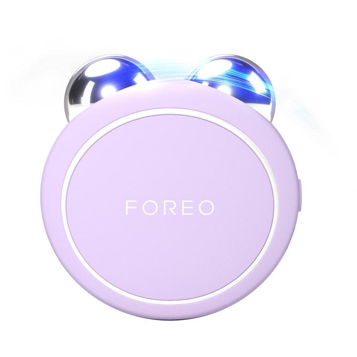 Foreo Bear 2 kiinteyttävä mikrovirtalaite on liila pyöreä laite jossa on kaksi hopeista palloa ja sinistä valoa.