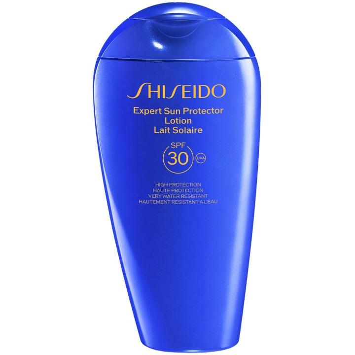Shiseido Expert Sun Protector Lotion SPF 30 aurinkovoide suojaa ihoa kirkkaansinisessä kaarevassa muovipullossa.
