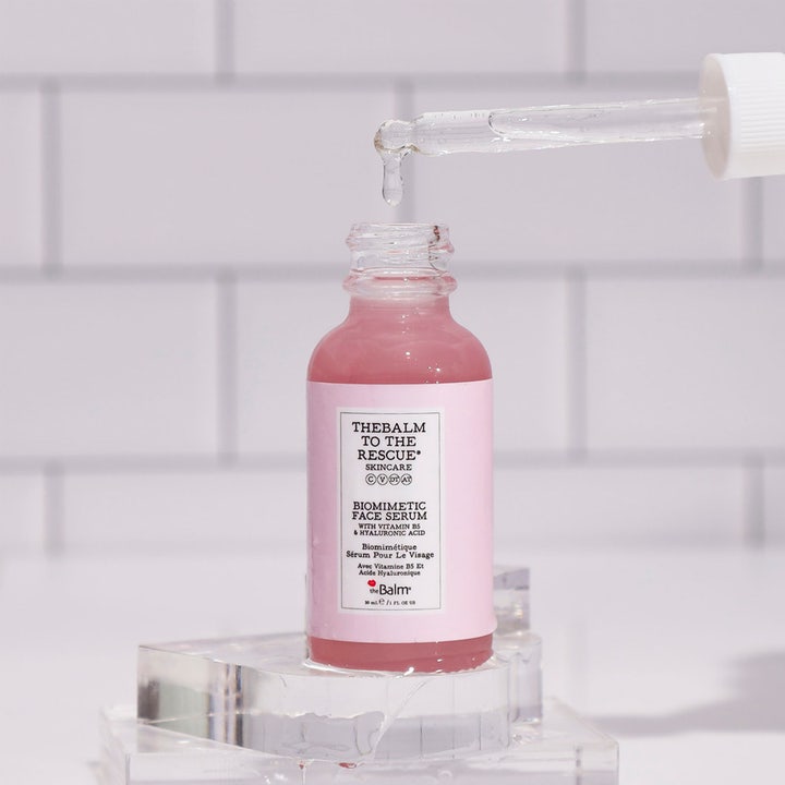 the Balm theBalm to the Rescue Biomimetic Face Serum 30 ml kasvoseerumi, pipetistä tippuva pinkki neste lasipullossa.