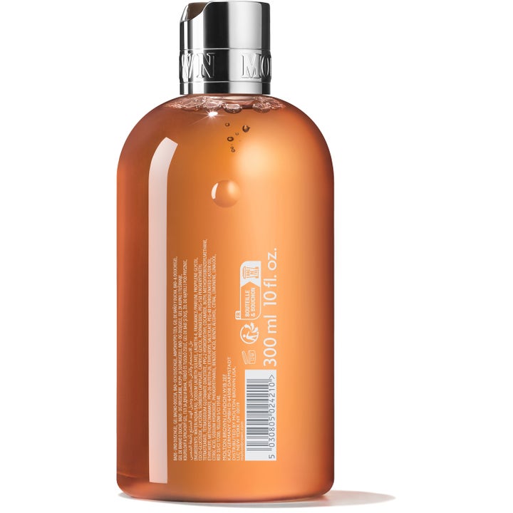 Molton Brown Sunlit Clementine & Vetiver 300 ml puhdistava suihkugeeli oranssissa pullossa takaa katsottuna.