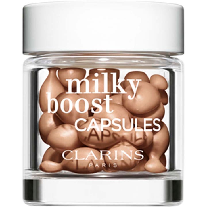 Clarins Milky Boost Capsules 30 kpl heleyttävä meikkituote kirkkaassa lasipurkissa täynnä beigejä kapseleita.