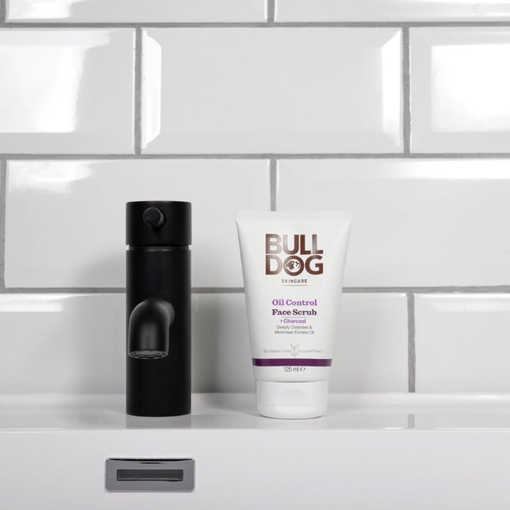 Bulldog Oil Control Face Scrub 125 ml kasvokuorinta vähentää rasvaisuutta valkoisessa tuubissa mustan hanan vieressä.