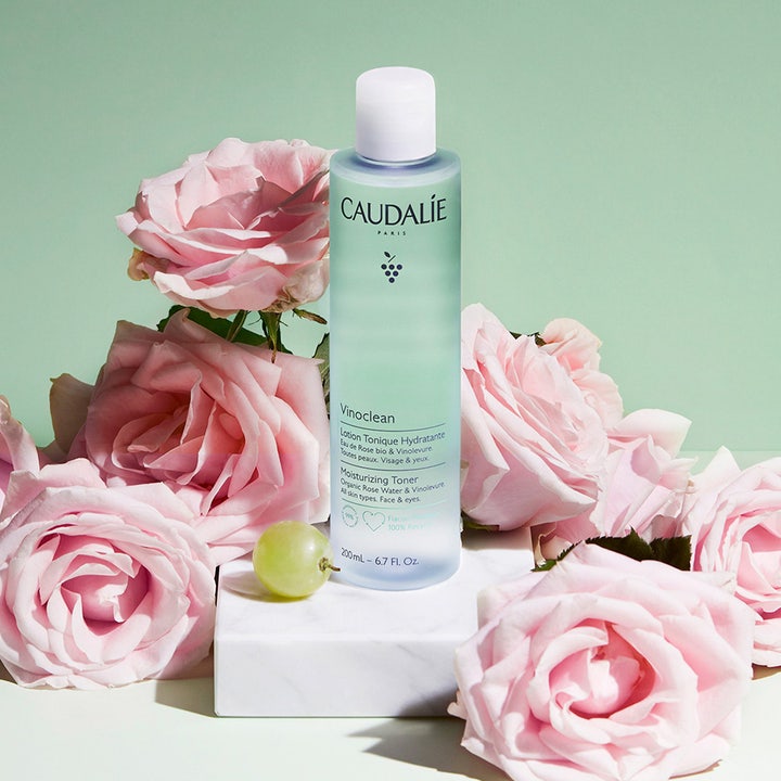 Caudalie Vinoclean Moisturizing Toner 200 ml kosteuttava kasvovesi vaaleanvihreässä pullossa ruusujen ja viinirypäleen keskellä