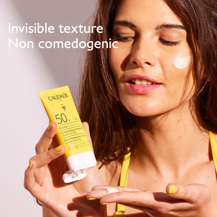 Caudalie Vinosun Protect Cream SPF50+ 50 ml kasvovoide ja nainen levittämässä näkymätöntä koostumusta.