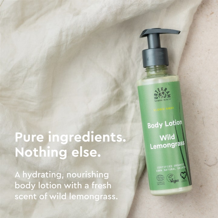 Urtekram Wild Lemongrass 245 ml kosteuttava vegaaninen vartalovoide vihreässä pumppupullossa vaalealla kankaalla.