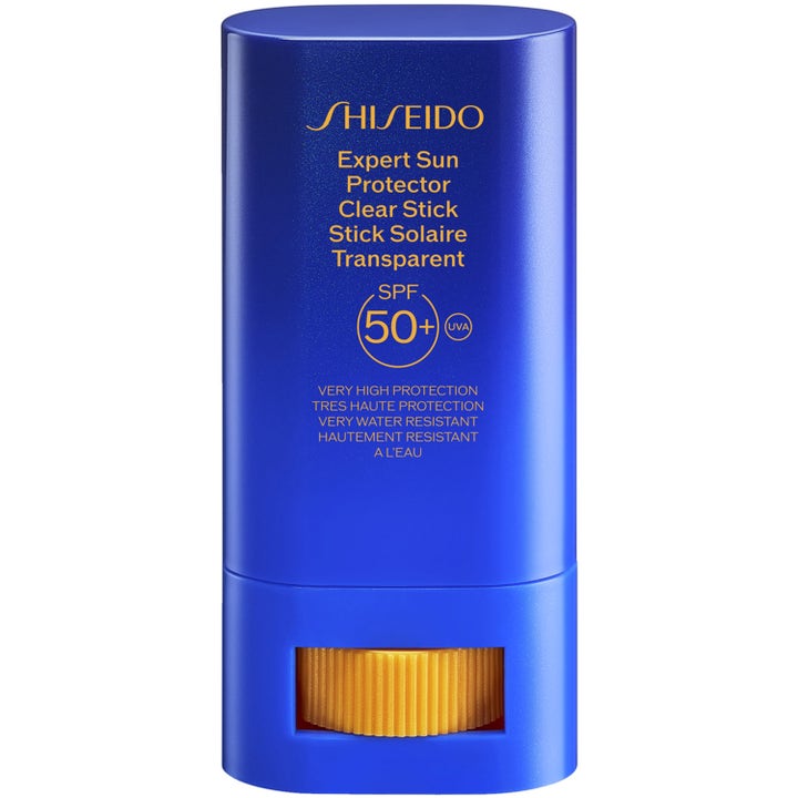 Shiseido Expert Sun Protector Clear Stick SPF 50+ aurinkosuojapuikko suojaa ihoa sinisessä hylsyssä keltaisella rullalla.
