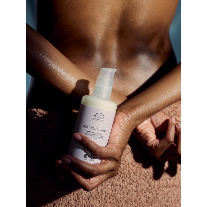 Rudolph Care Açai Body Lotion 200 ml kosteuttava vartalovoide vaaleassa pumppupullossa henkilön käsissä