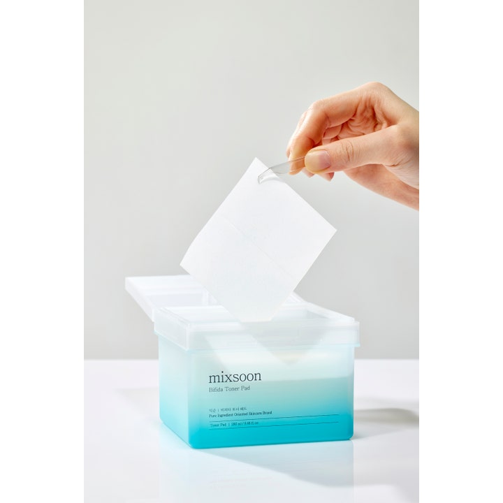 Mixsoon Bifida Toner Pad 120 kpl vahvistava kasvovesi käsi nostaa neliönmuotoisen lapun pinseteillä sinisestä rasiasta