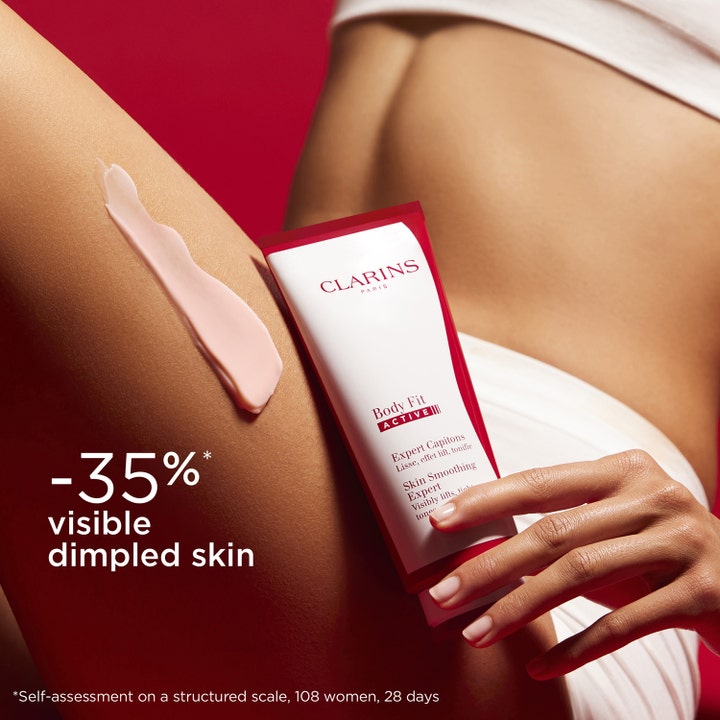 Clarins Body Fit Active 200 ml silottava vartalovoide vaaleanpunaisena voiteena iholla ja valkoisena tuubina