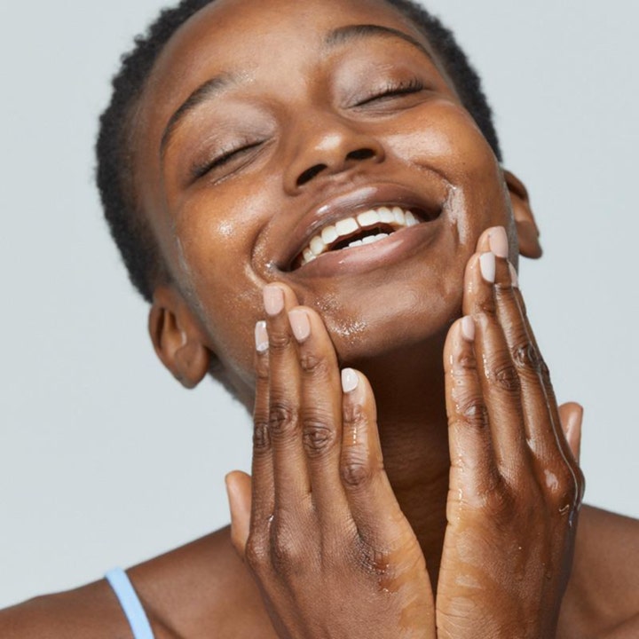 Dermalogica PreCleanse 30 ml puhdistusöljy syväpuhdistaa ihon hymyilevän naisen hieroessa tuotetta kasvoilleen.