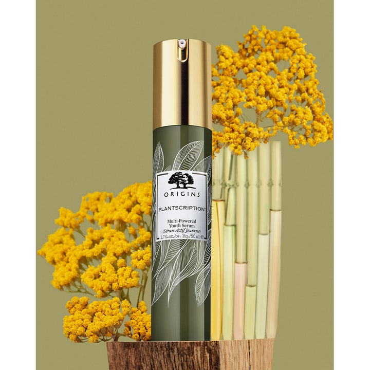 Origins Plantscription Multi-Powered Youth Serum 30 ml uudistava seerumi vihreässä pullossa keltaisten kukkien ympäröimänä.