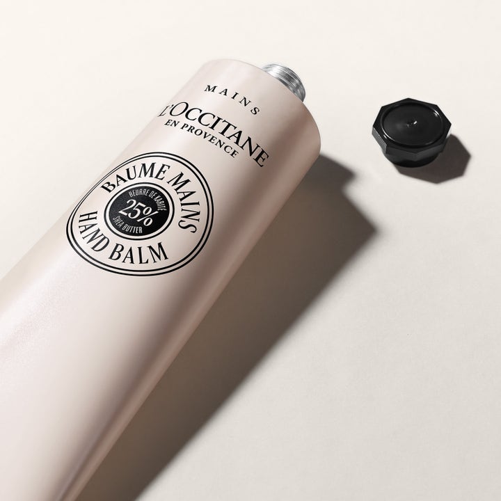 L'Occitane en Provence Shea Butter Hand Balm 150 ml ravitseva käsivoide vaaleassa tuubissa ja irrotettu musta korkki