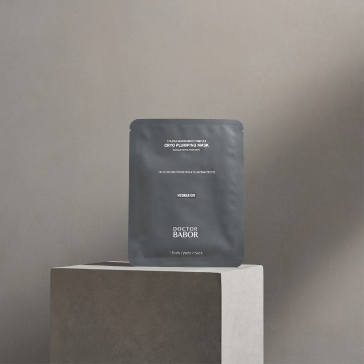 Babor Doctor Babor Cryo Plumping Mask 1 kpl kosteuttava kangasnaamio harmaassa pussissa kivisellä jalustalla.