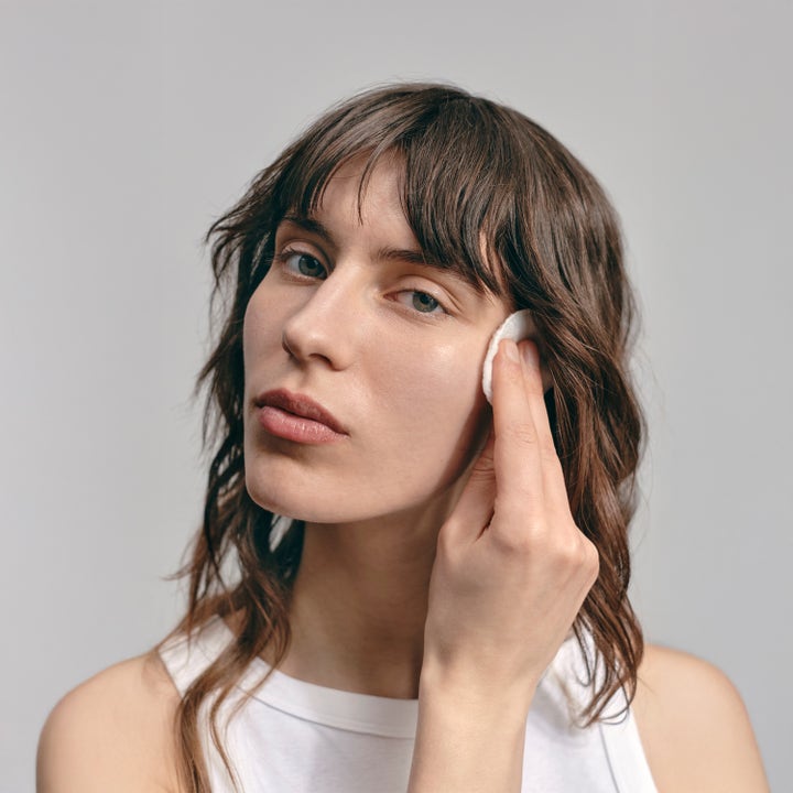 Jorgobé BHA Exfoliator 150 ml kuoriva seerumi puhdistaa ihoa, nainen levittää tuotetta vanulapun avulla.