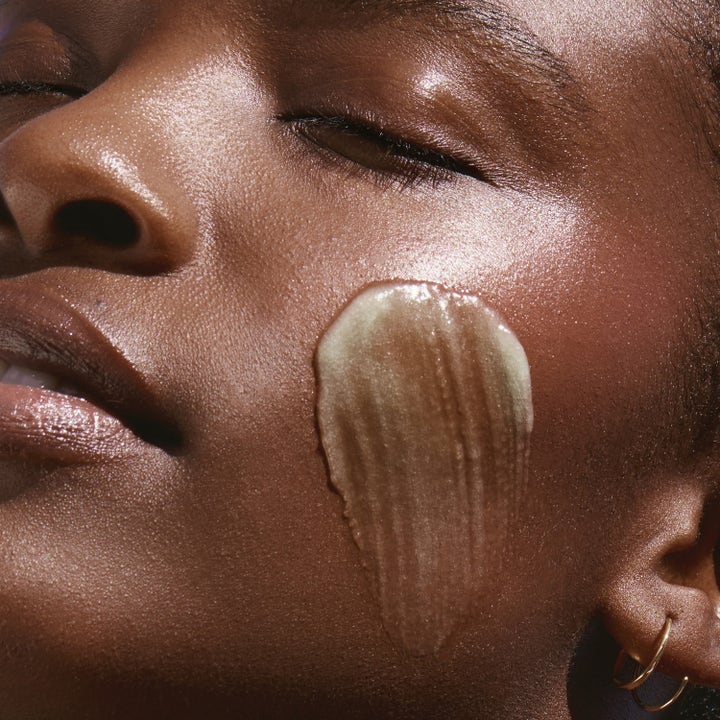 KORA Organics Active Algae Melting Cleansing Balm 30 g puhdistusbalsami siveltynä poskelle näyttäen tuotteen koostumuksen.