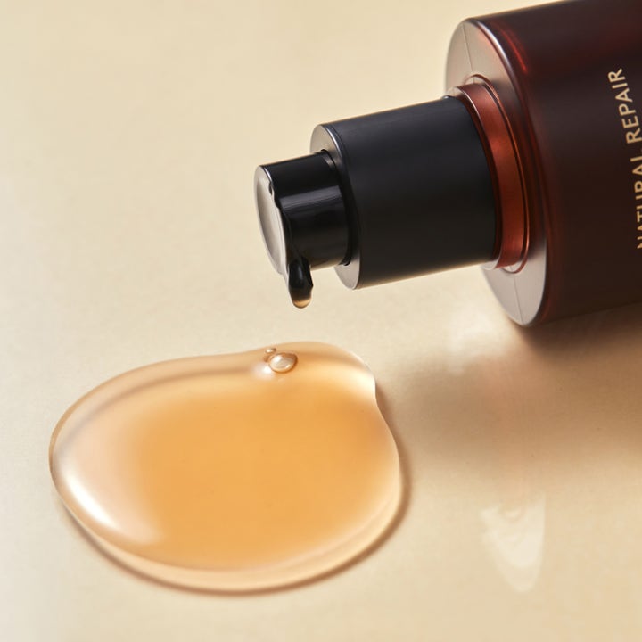 Hyggee Natural Repair Serum 120 ml uudistava seerumi ruskea pumppupullo ja pisara kullanhohtoista nestettä