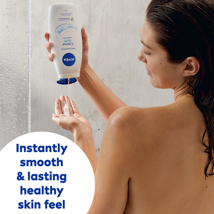 NIVEA Creme Soft Shower 250 ml kosteuttava suihkusaippua jota nainen kaataa pullosta kämmenelleen suihkussa