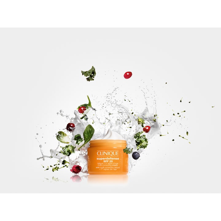 Clinique Superdefense SPF25 30 ml kirkastava päivävoide oranssissa purkissa marjojen ja kasvisten keskellä.