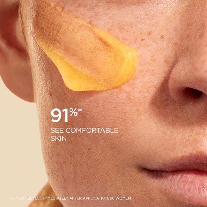 Clarins Comfort Scrub 50 ml ravitseva kuorintavoide keltaisena tekstuurina iholla ja teksti 91% see comfortable skin