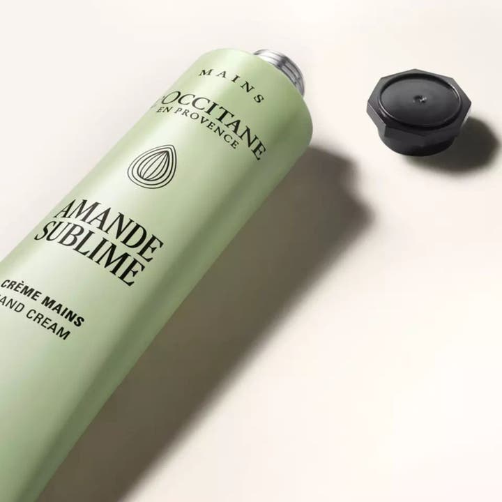 L'Occitane en Provence Almond Delicious Hands 75 ml pehmittävä käsivoide vaaleanvihreässä tuubissa avatulla korkilla.