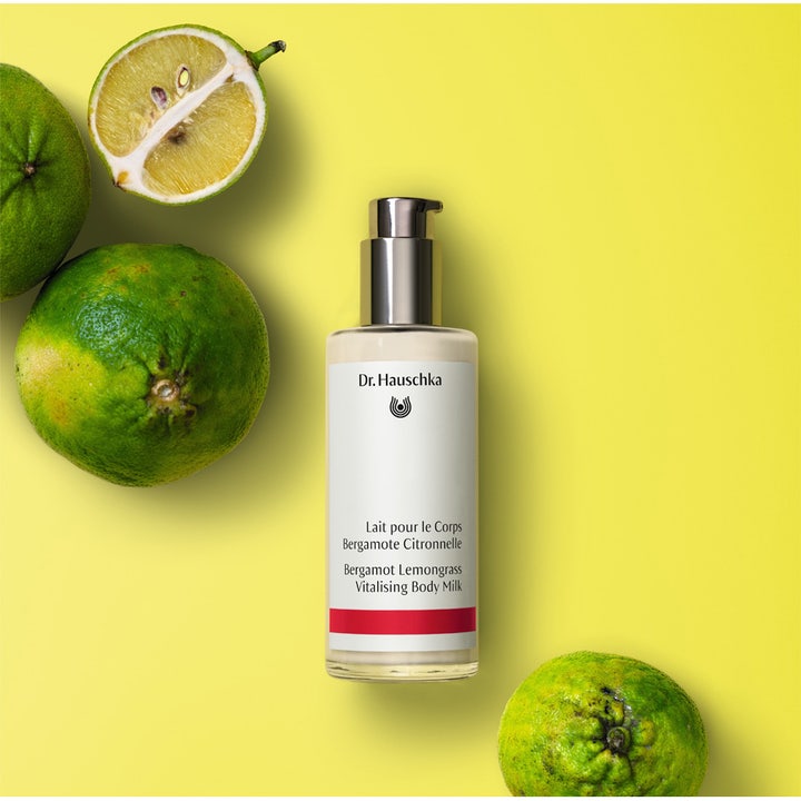Virkistävä Dr. Hauschka Bergamotte Lemongrass Vitalising Body Milk 145 ml vartalovoide ja tuoreita sitrushedelmiä.