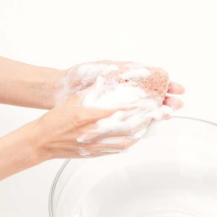 Purito JEJU Volcanic Scoria Konjac Sponge 7 g puhdistava kasvosieni luo runsaan valkoisen vaahdon käsissä.