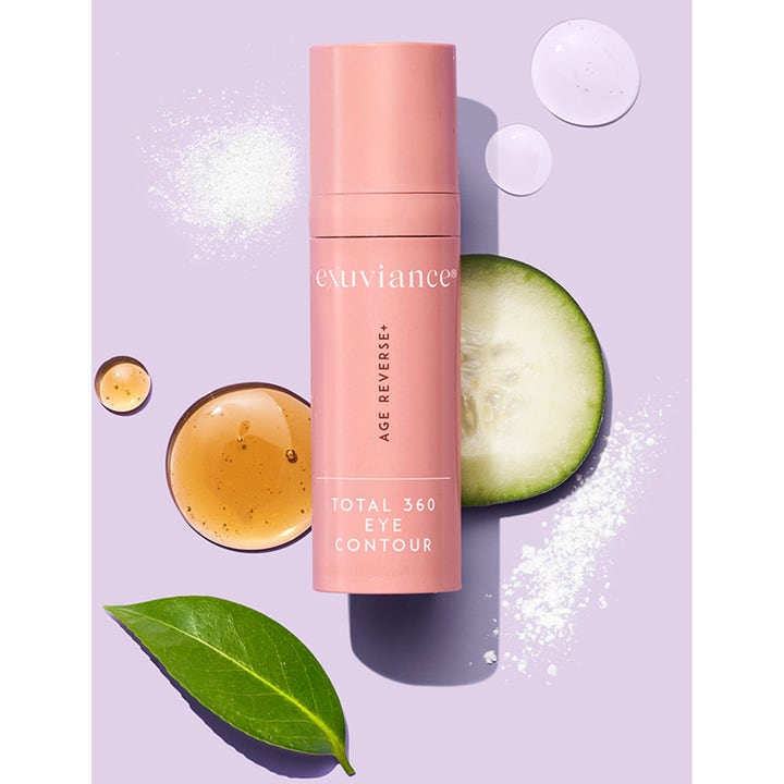 Exuviance Age Reverse Eye Contour 15 g silmänympärysvoide vaaleanpunaisessa pullossa kurkkuviipaleen ja lehtien kera.