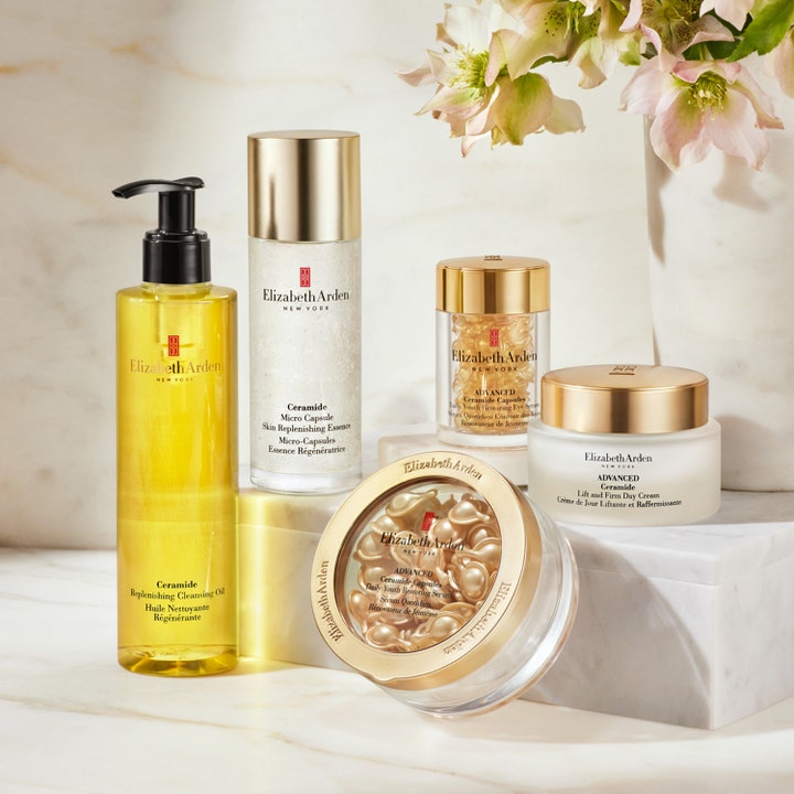 Elizabeth Arden Replenishing Cleansing Oil 200 ml puhdistusöljy ja muita kultaisia ihonhoitotuotteita asetelmana.