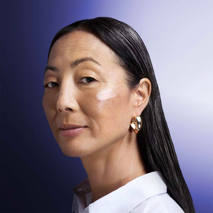 Shiseido Vital Perfection Overnight Firming Treatment 80 ml kiinteyttävä yövoide levitettynä naisen kasvoille.