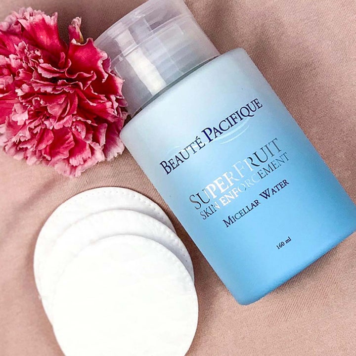 Beauté Pacifique Superfruit Micellar Water 160 ml puhdistusvesi vaaleansinisessä pullossa kukan vieressä.