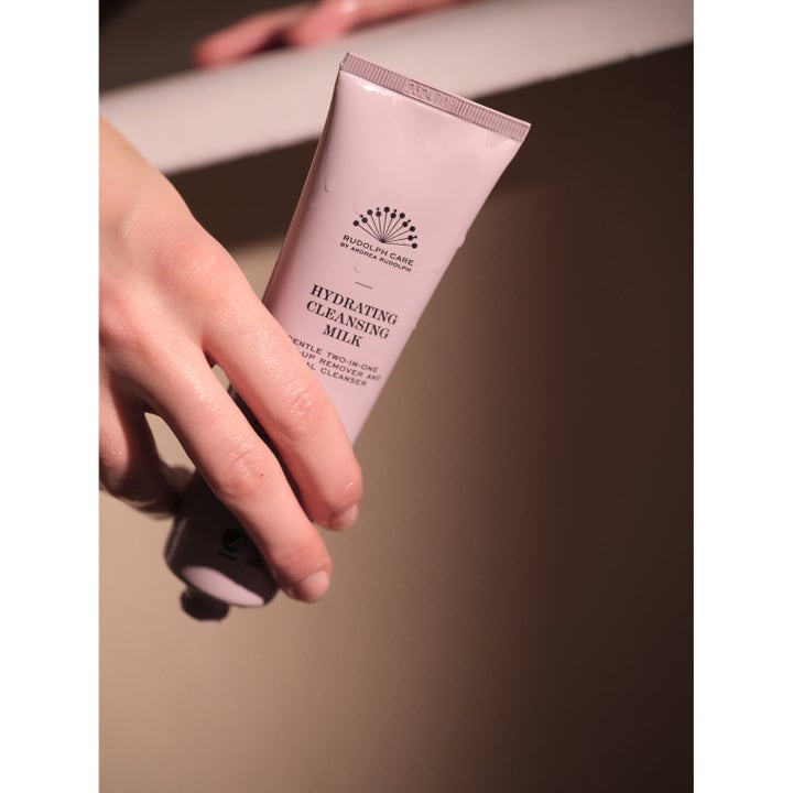Rudolph Care Acai Hydrating Cleansing Milk 100 ml kosteuttava puhdistusemulsio vaaleanpunaisessa tuubissa kädessä