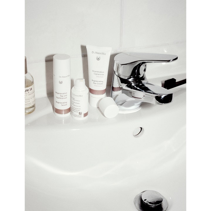 Dr. Hauschka Regenerating Day Cream 40 ml uudistava päivävoide valkoisessa tuubissa kylpyhuoneen pesualtaalla.