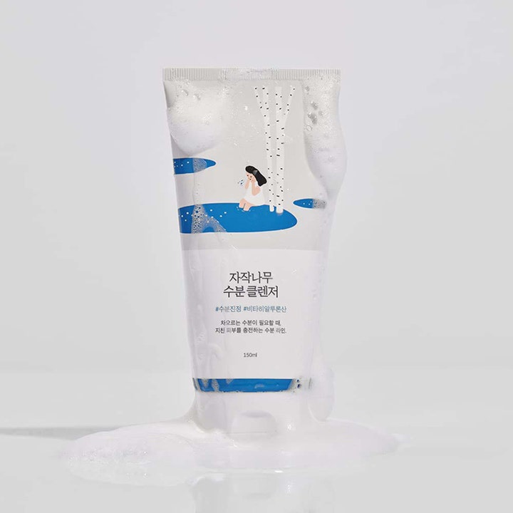 Round Lab Birch Juice Moisturizing Cleanser 150 ml kosteuttava puhdistusaine koivukuvioidussa tuubissa vaahdon keskellä