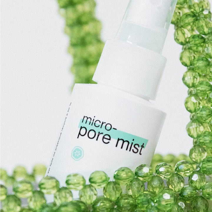 Dermalogica Clear Start Micro-Pore Mist niasiiniamidi kasvovesi valkoisessa pullossa vihreiden helmien ympäröimänä.