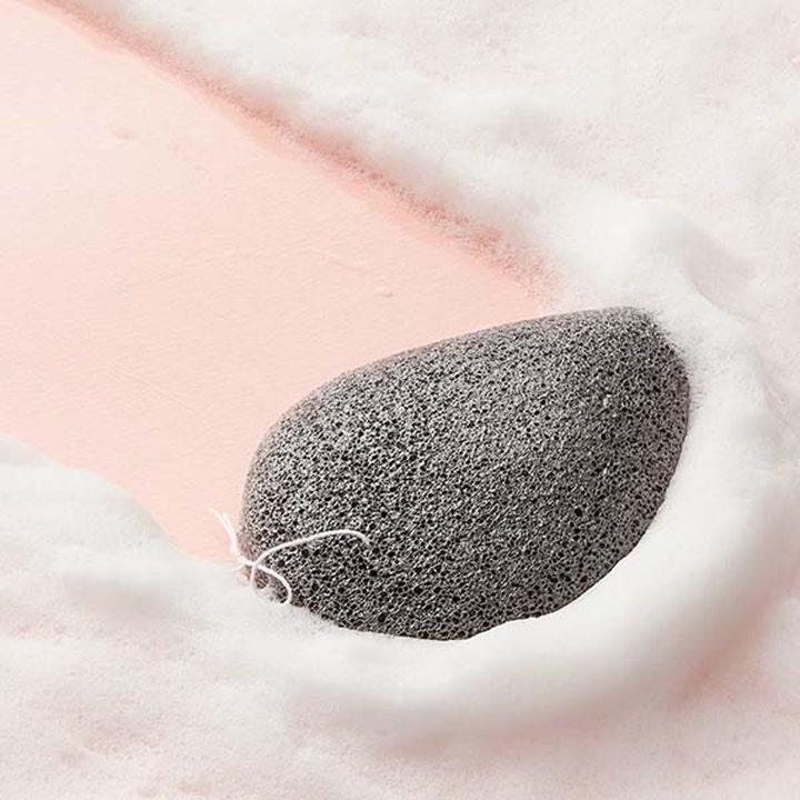 Purito JEJU Volcanic Scoria Konjac Sponge 7 g puhdistussieni harmaa huokoinen sieni pehmeän valkoisen vaahdon keskellä
