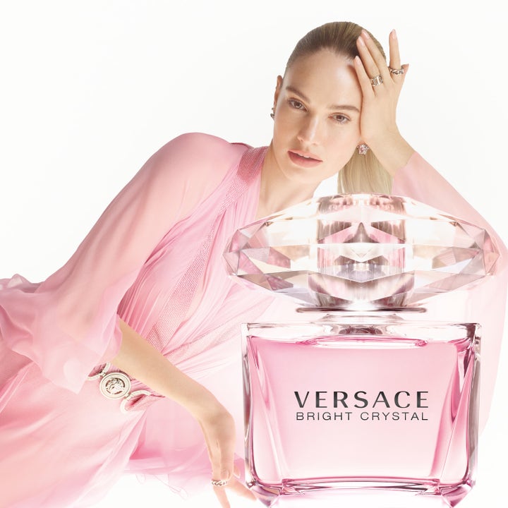 Versace Bright Crystal 50 ml deodorantti raikas kukkainen tuoksu kampanjakuvassa vaaleanpunaisen pullon ja mallin kera.
