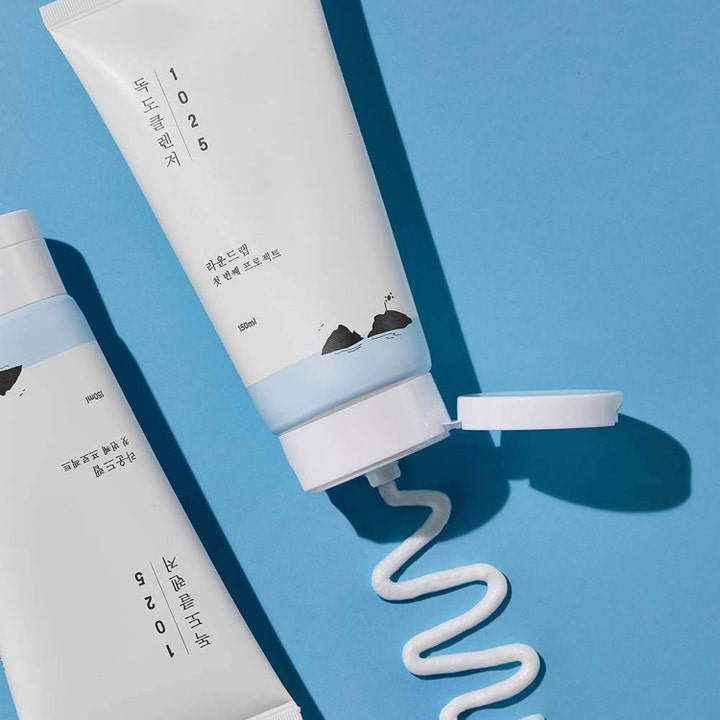 Round Lab 1025 Dokdo Cleanser 150 ml puhdistava kasvojenpuhdistusaine ja tuubista pursuava kermainen valkoinen koostumus.