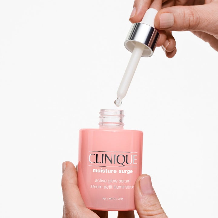 Clinique Moisture Surge Active Glow Serum 80 ml heleyttävä kasvoseerumi vaaleanpunaisessa pullossa pipetillä.