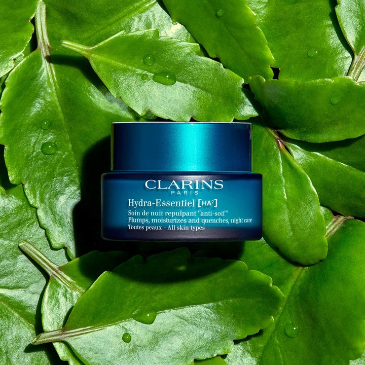 Clarins Hydra-Essentiel 50 ml kosteuttava yövoide sinisessä lasipurkissa vihreiden lehtien päällä.