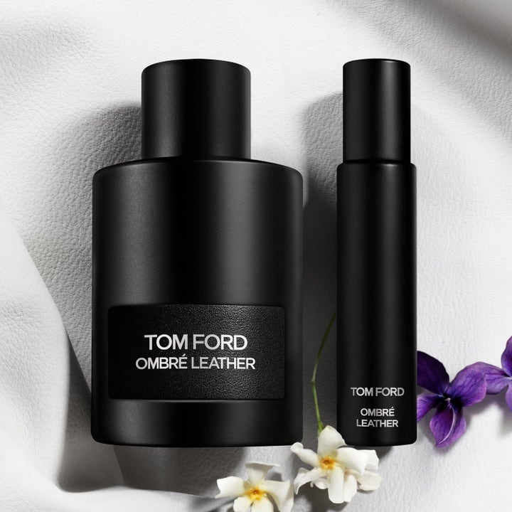 Tom Ford Ombré Leather EdP parfyymi ja matkasuihke mattamustissa pulloissa valkoisella nahalla ja kukilla