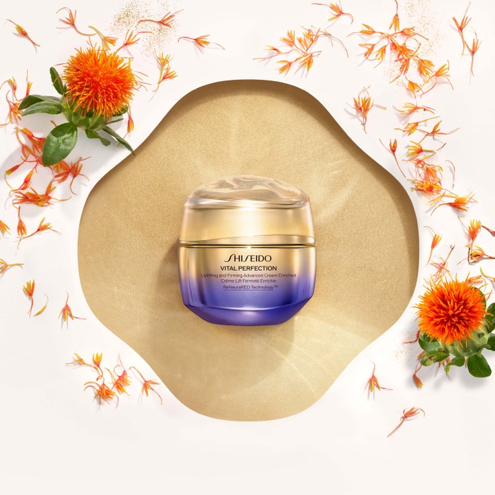 Shiseido Vital Perfection Advanced Cream Enriched 50 ml kiinteyttävä päivävoide kultaisessa purkissa kukkien ympäröimänä