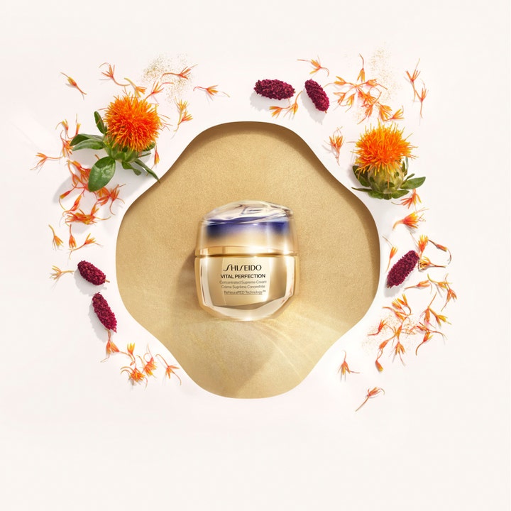Shiseido Vital Perfection Concentrated Supreme Cream 50 ml kiinteyttävä kasvovoide kultaisessa lasipurkissa saflori kukkien ympäröimänä.