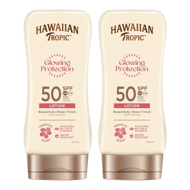 Kaksi Hawaiian Tropic Glowing Protection SPF 50 180 ml aurinkovoidetta vaaleissa muovipulloissa pronssisilla korkeilla.