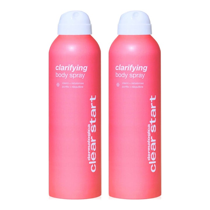 Dermalogica Clear Start Clarifying Body Spray kaksi vaaleanpunaista puhdistavaa vartalosuihketta valkoisilla korkeilla.