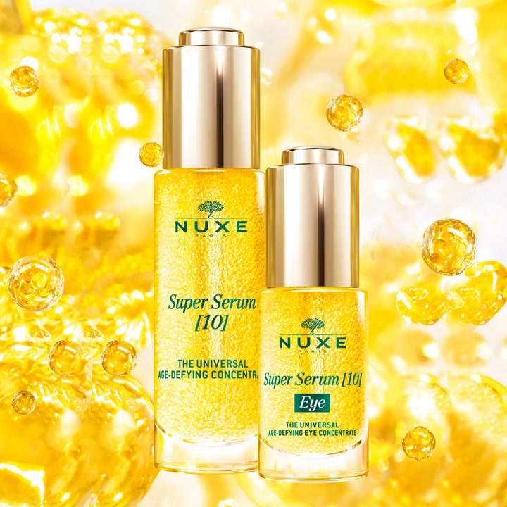 Nuxe Super Serum [10] Eye 15 ml silmänympärysseerumi kultaisessa pipettipullossa keltaisella taustalla