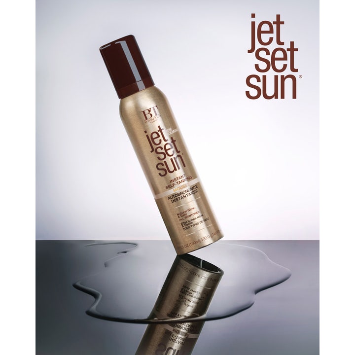 Jet Set Sun Mousse 150 ml itseruskettava vaahto kultaisessa pullossa heijastumassa veden pinnasta.