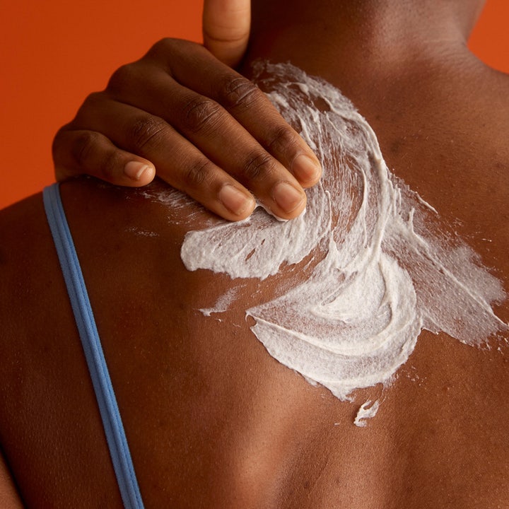 Frank Body Glycolic Body Scrub 250 g kirkastava vartalokuorinta levitettynä iholle valkoisena voiteena.