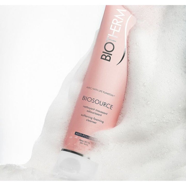 Biotherm Biosource Softening Foaming Cleanser kuivalle iholle vaaleanpunaisessa tuubissa valkoisen vaahdon ympäröimänä.