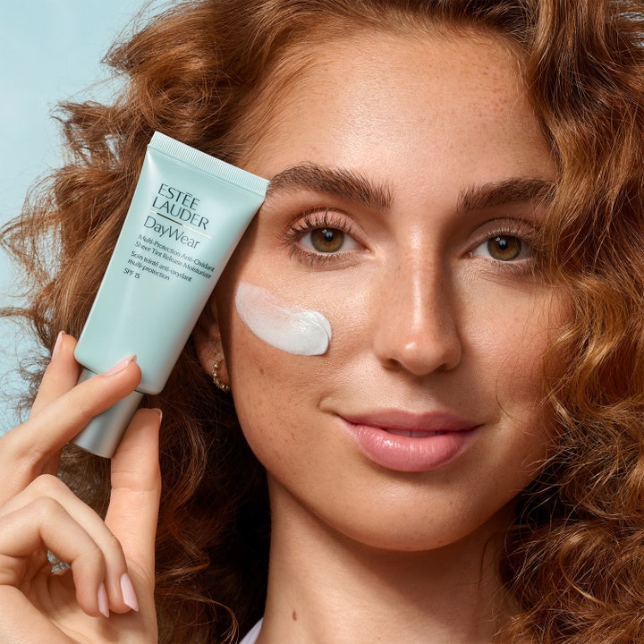 Estée Lauder DayWear Sheer Tint Release Moisturizer SPF15 50 ml kosteusvoide ja nainen jolla on voidetta kasvoilla.
